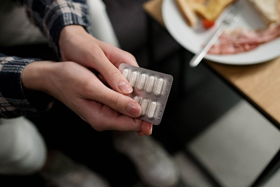 Photo Of Hand Holding Pills Showing Tolerance Of A Drug