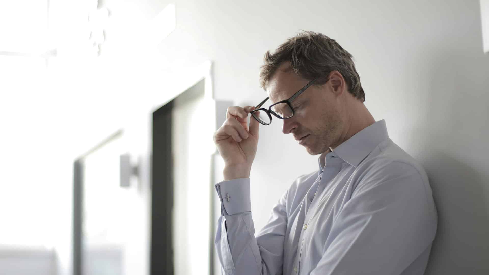 photo of man holding black eyeglasses