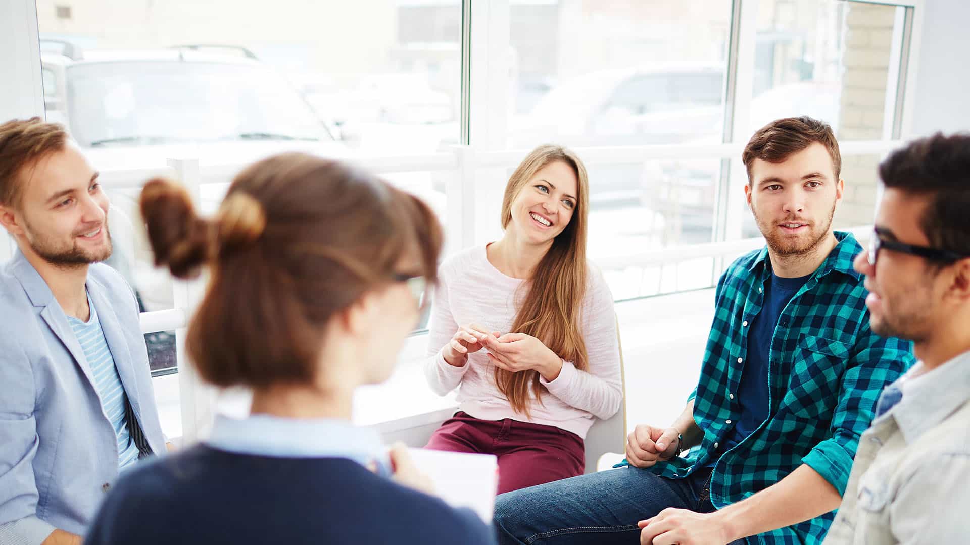 diverse group of people sitting in circle in group